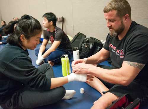 Coach Matt wraps a student's hands before a Muay Thai fight.